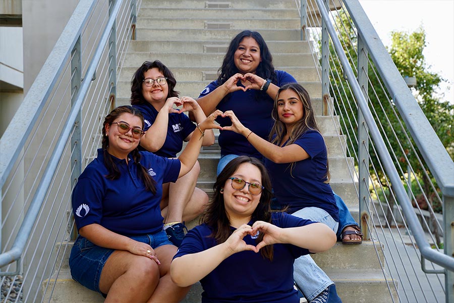 group photo of uc merced care staff holding hands forming of a heart